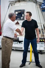 Musk shakes hands with NASA Administrator Charles Bolden before a SpaceX Dragon capsule