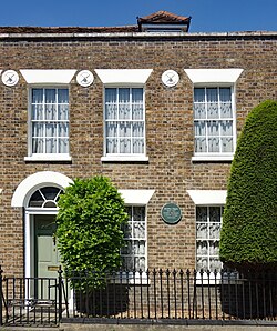 Front of a two-story Georgian house. A green plaque reads "Dorothy L. Sayers 1983-1957 novelist theologian & Dante scholar lived here"