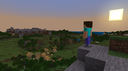 The default player skin, Steve, stands on a cliffside overlooking a village in a forest. In the distance, there is a small mountain range. The sun is setting to the right, making the sky turn pink and blue.