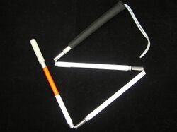 White cane with red band, folded into four segments