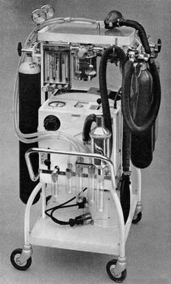 A machine with hoses and gauges on a wheeled cart