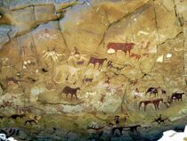 A cave wall painted with camels and cattle