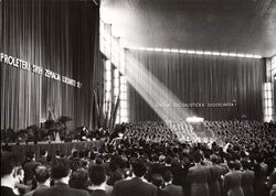 Photograph of hundreds of people in an auditorium
