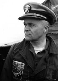 portrait photograph of a man wearing the uniform of an officer of the United States Navy, with the rank of commander.