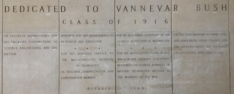Four large panels with words carved in stone. The inscriptions reads: "Dedicated to Vannevar Bush Class of 1916. An engineer distinguished for his creative contributions to science, engineering and the nation. Honored for his achievements in research and education. For his devoted service to the Massachusetts Institute of Technology as teacher, administrator and corporation member. For his acclaimed leadership of the Carnegie Institute of Washington. For his mobilization during World War II of the nation's scientific resources to achieve advances in military technology decisive in the winning of the war. For his statesmanship in formulating and advocating sound policies for the advancement of science, engineering and education. 1 October 1965"