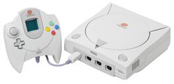 A Dreamcast. It is a white system with a disk drive on top and a controller with a display screen attached