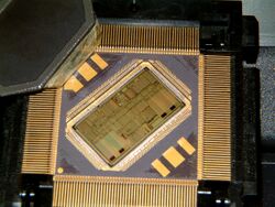 Computer chip with lid removed showing silicon die installed at an angle