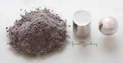 Rhodium powder, a rhodium cylinder, and a rhodium pellet in a row