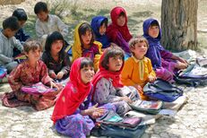 Photo of school children sitting in the shade of an orchard in Bamozai, near Gardez, Paktia Province, Afghanistan