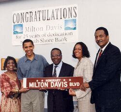 Photo of Obama and others carrying a streetsign that reads "Honorary: Milton Davis Blvd."