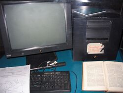 A NeXT Computer workstation has a black monitor, system box, keyboard, and mouse.