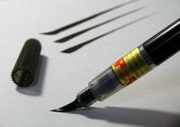 Picture of a brush pen being used to apply ink to paper.