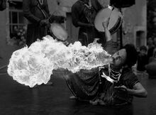 A grayscale image showing the CIELAB lightness component of the photograph appears to be a faithful rendering of the scene: it looks roughly like a black-and-white photograph taken on panchromatic film would look, with clear detail in the flame, which is much brighter than the man's outfit or the background.