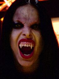 A woman showing teeth with fangs.