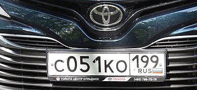 A Russian license plate with the value "C051KO199" is mounted on the front grille of a Toyota car
